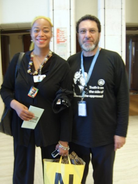 IHRC Chair Massoud Shadjareh wearing IHRC’s Malcolm X T-Shirt with Malcom X’s daughter, Malaak Shabazz Alert: Global – IHRC Shop Competition. Send us your photos and win prizes